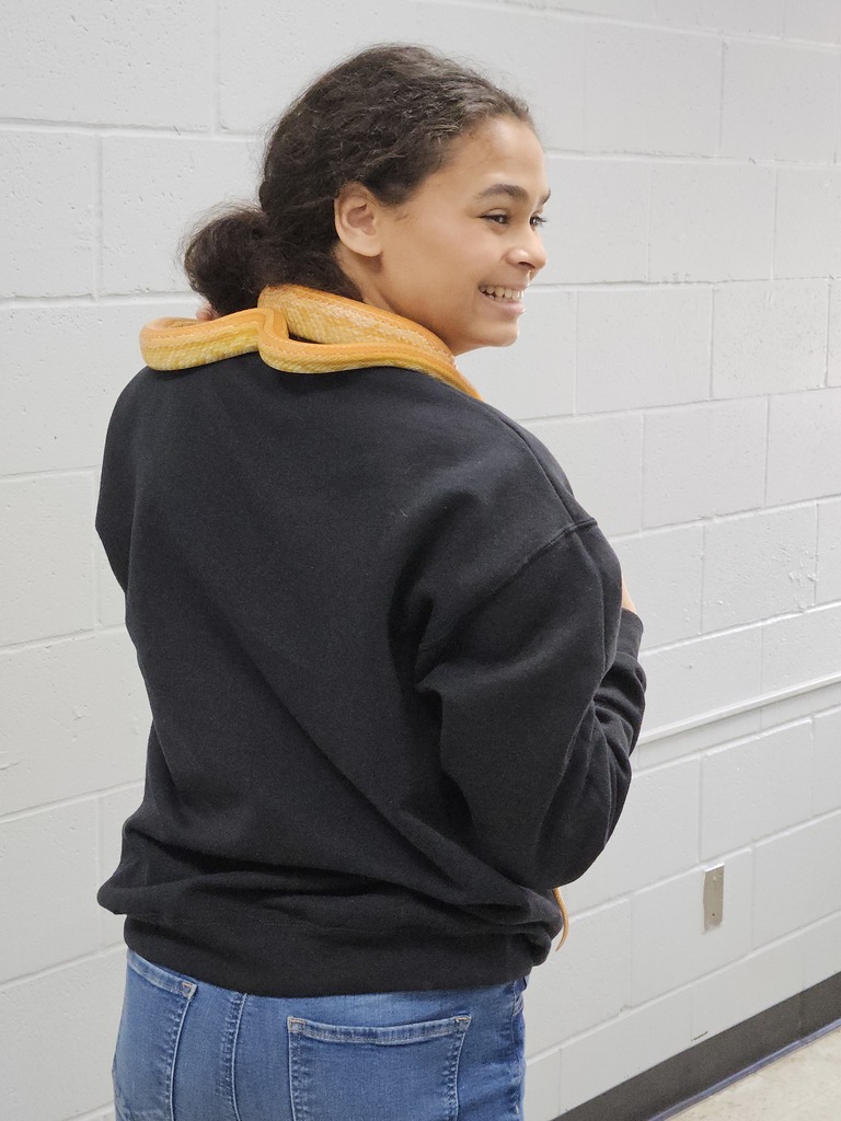 A student has her back to the camera.. She has Loki around her neck. 