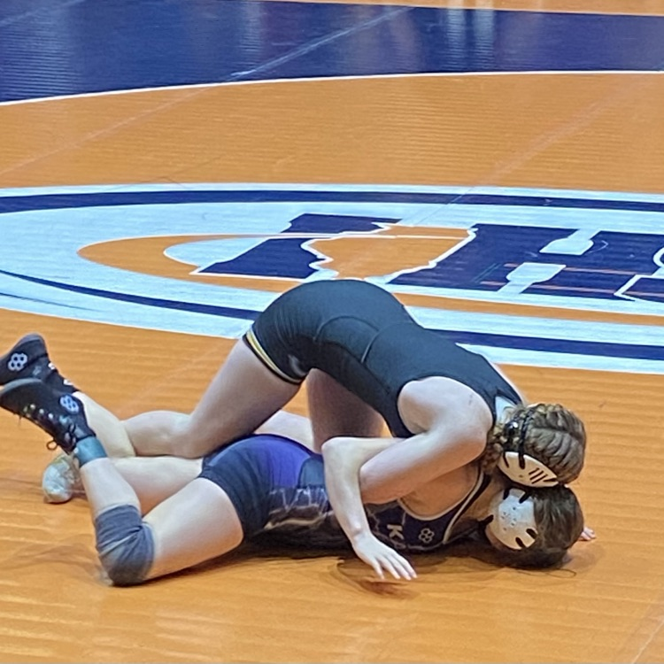 NB is on her opponent’s back maneuvering a pin. She had the opponent’s arms held back  
