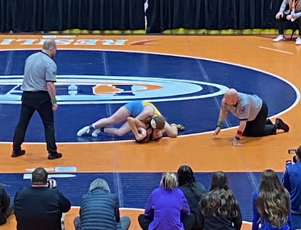 NB has fallen on the opponent attempting a pin. The referee is on all fours to watch. 