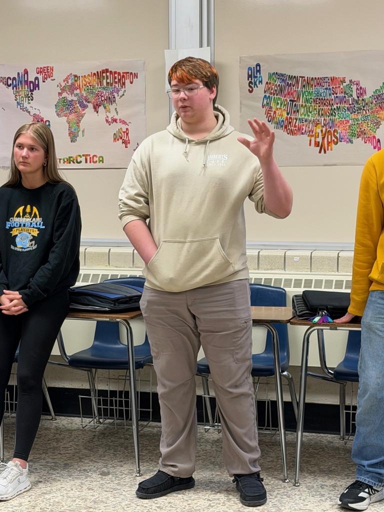 A student is standing at the strongly disagree wall and explaining his opinion. 