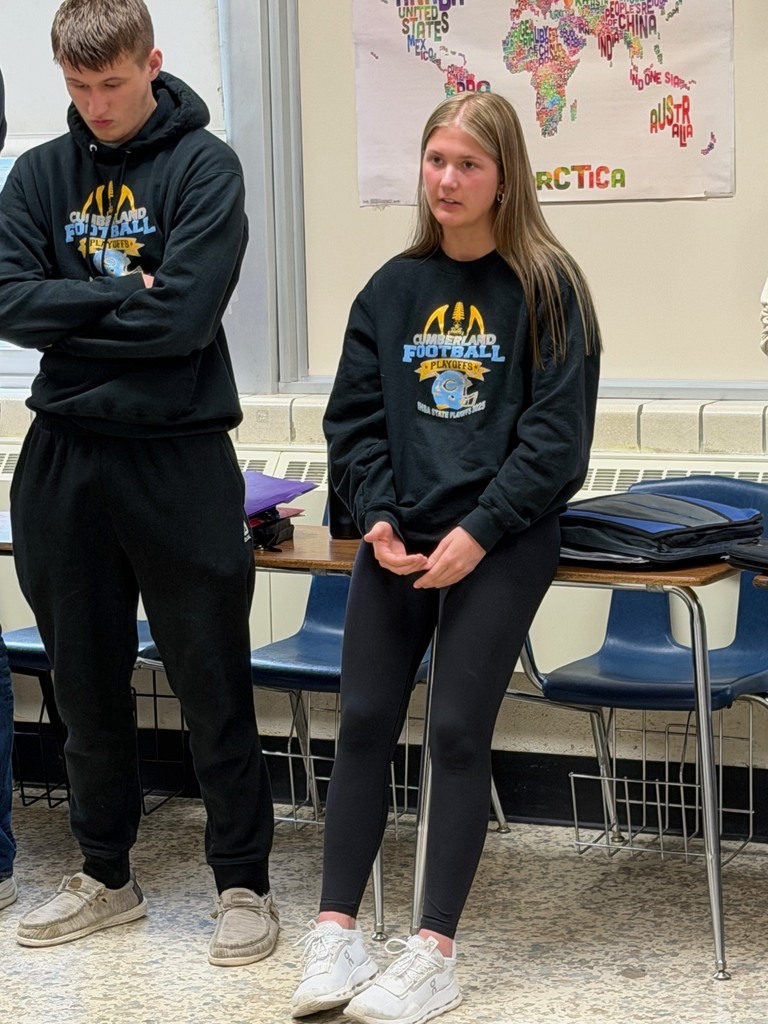 Two students are standing at the strongly disagree wall and one is explaining her opinion. 