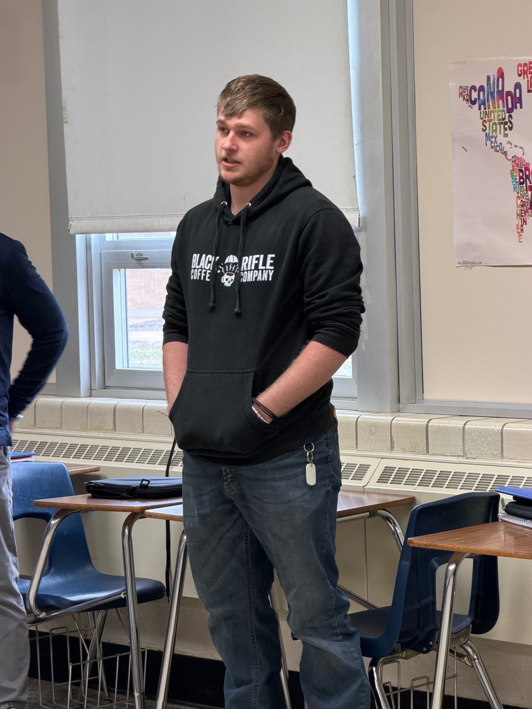 A student is standing at the strongly disagree wall and explaining his opinion. 