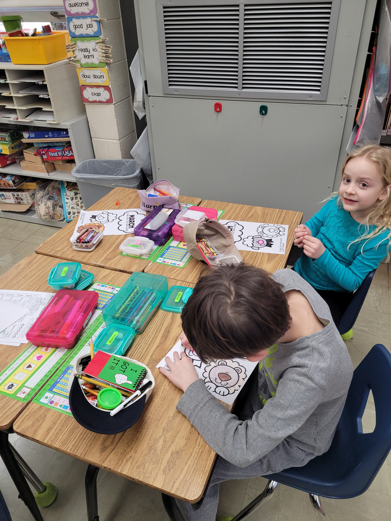 Two students are coloring their March in like a lion out like a lamb worksheets. 