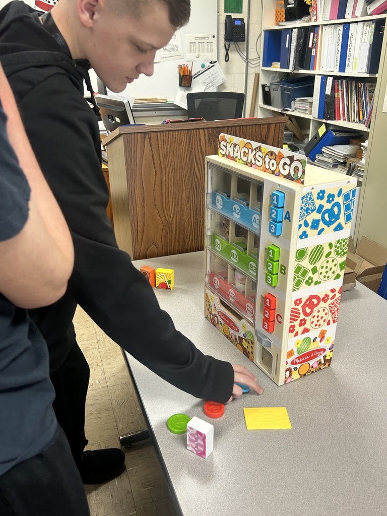 A student is selecting money to put into the classroom vending machine. 
