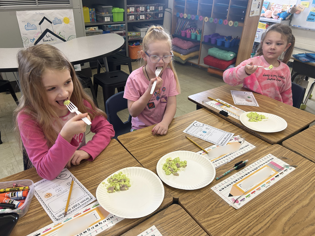 Three students re trying Green Eggs and Ham. 