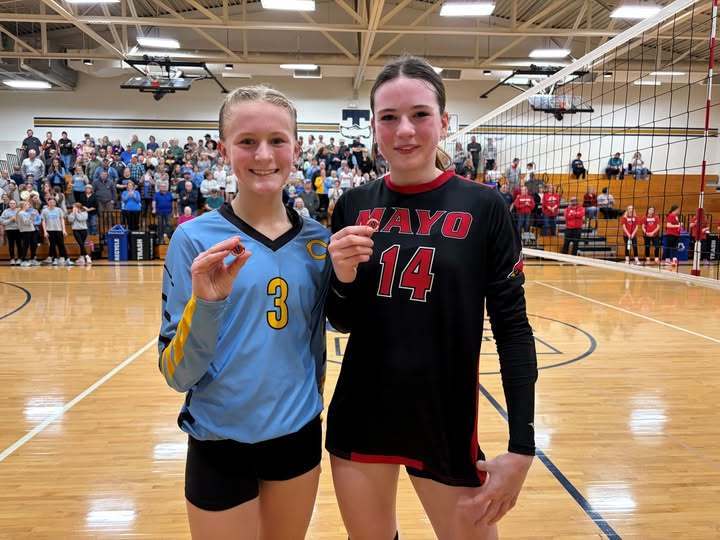 KR is standing with an opponent. Each are holding the sportsmanship pin. 