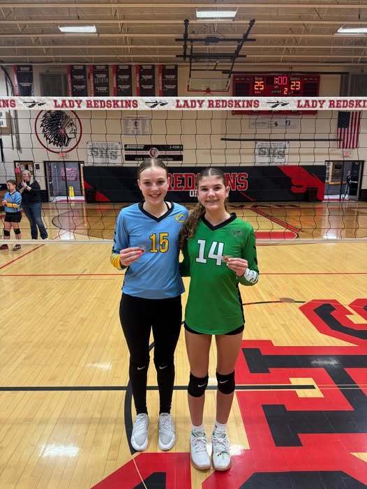 HN is standing with an opponent. Each are holding the sportsmanship pin. 