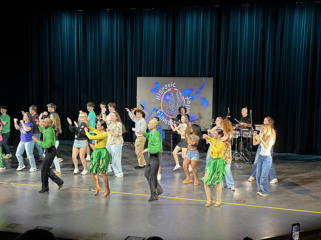 Four performers are teaching students how to do a Soanish style of dance.