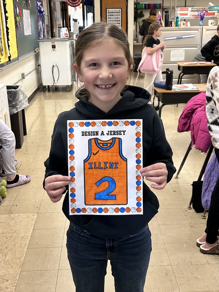 A student is holding up her jersey coloring. 