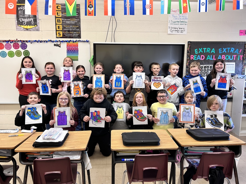 The class is standing or kneeling in two rows. They are holding up their jerseys.