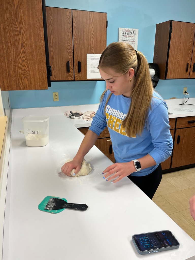A student is kneeding the dough. 