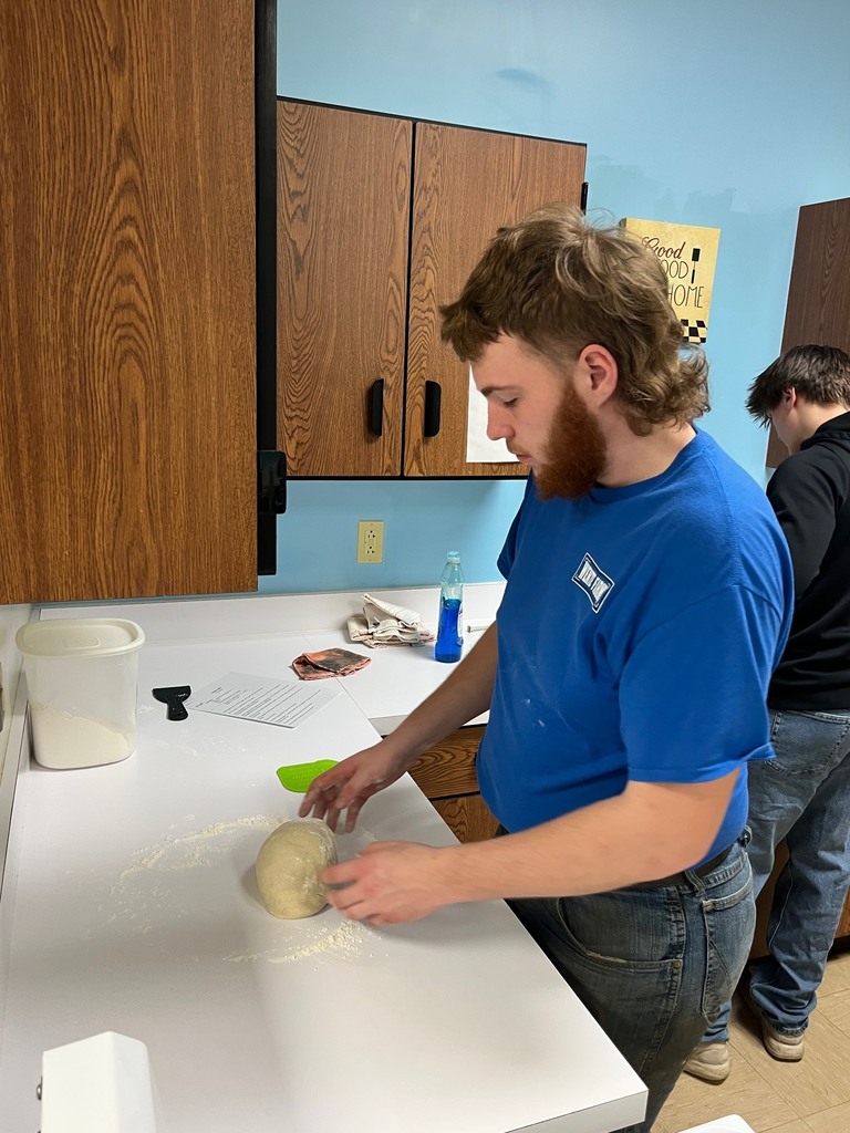 A student is kneeding the dough. 