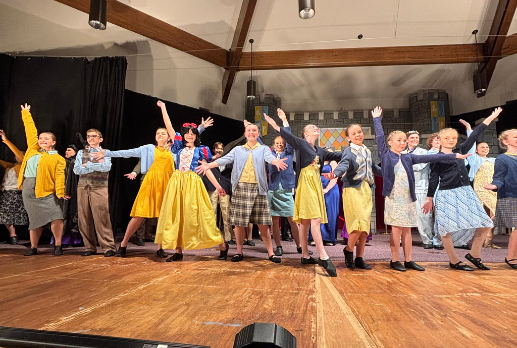 Many cast members are dancing on stage.