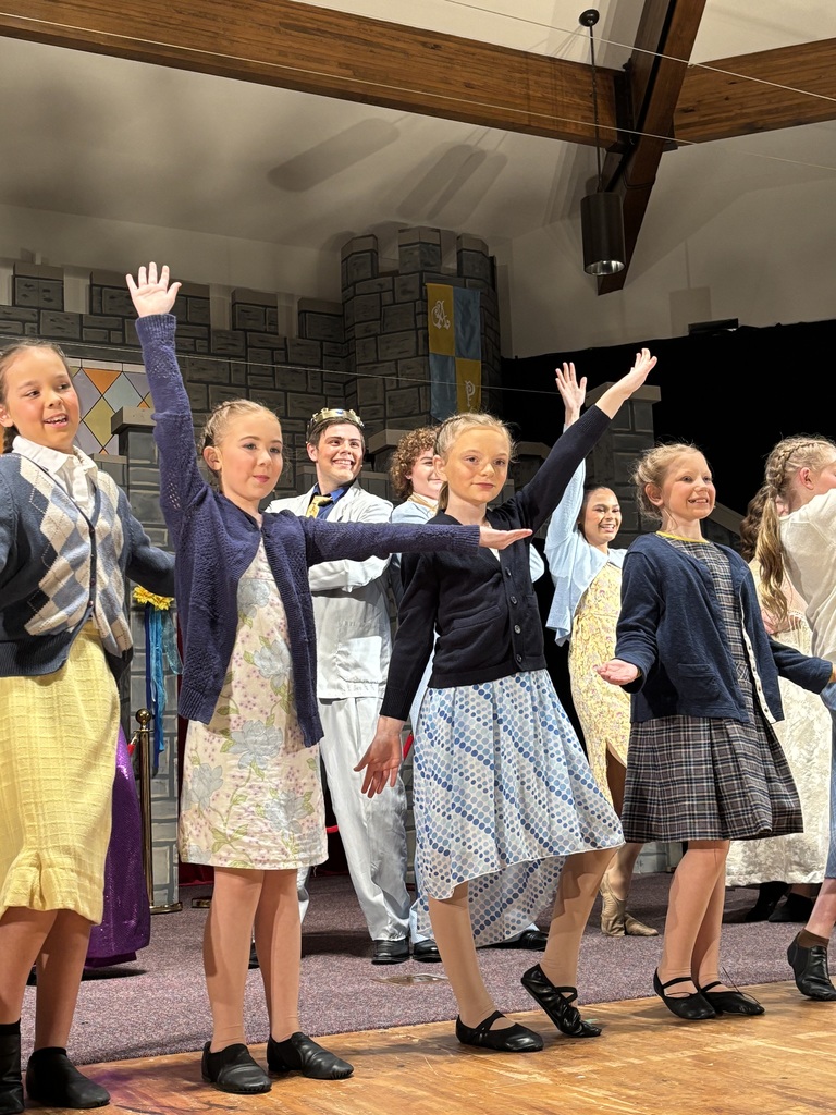 Many cast members are dancing on stage.