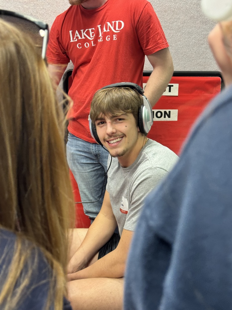 A student is wearing headphones and listening to the radio broadcast. 