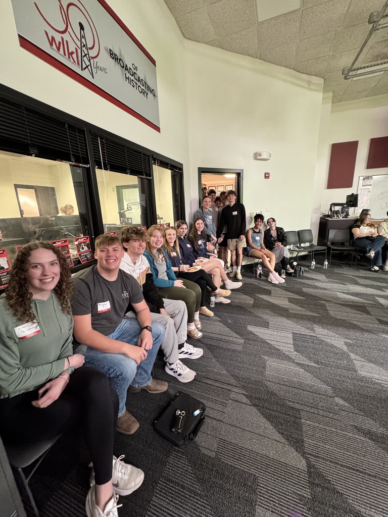 The entire speech class os sitting or standing at the door waiting for their turn. 