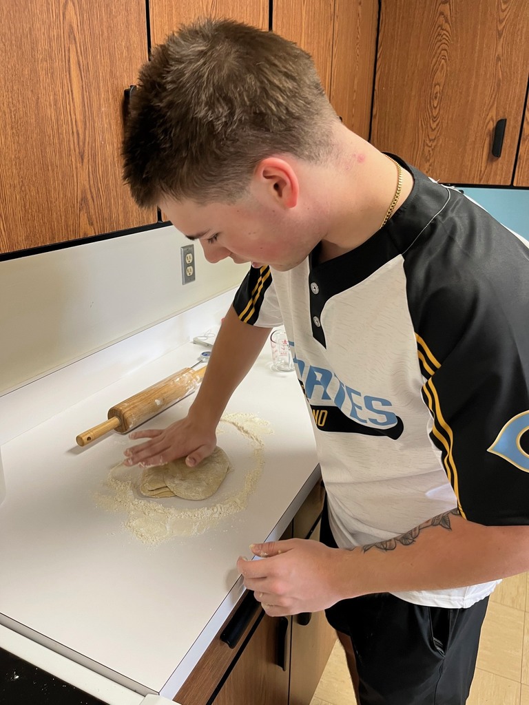 A student is flattening the dough. 