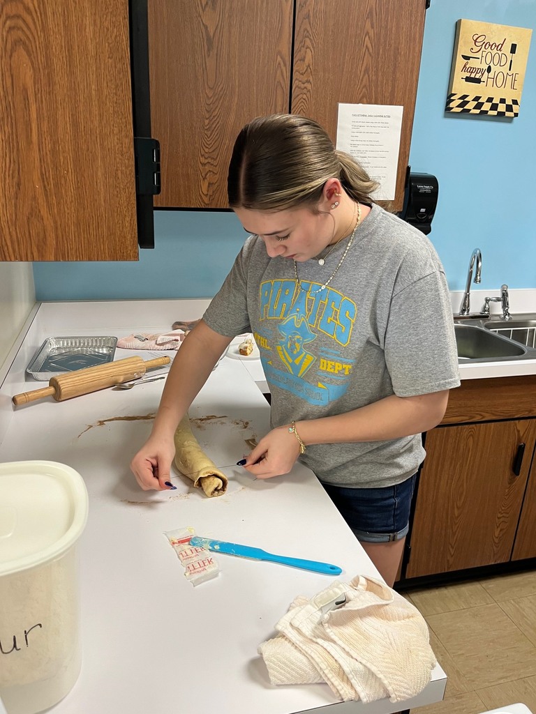 A student is cutting the rolled up rolls with floss. 