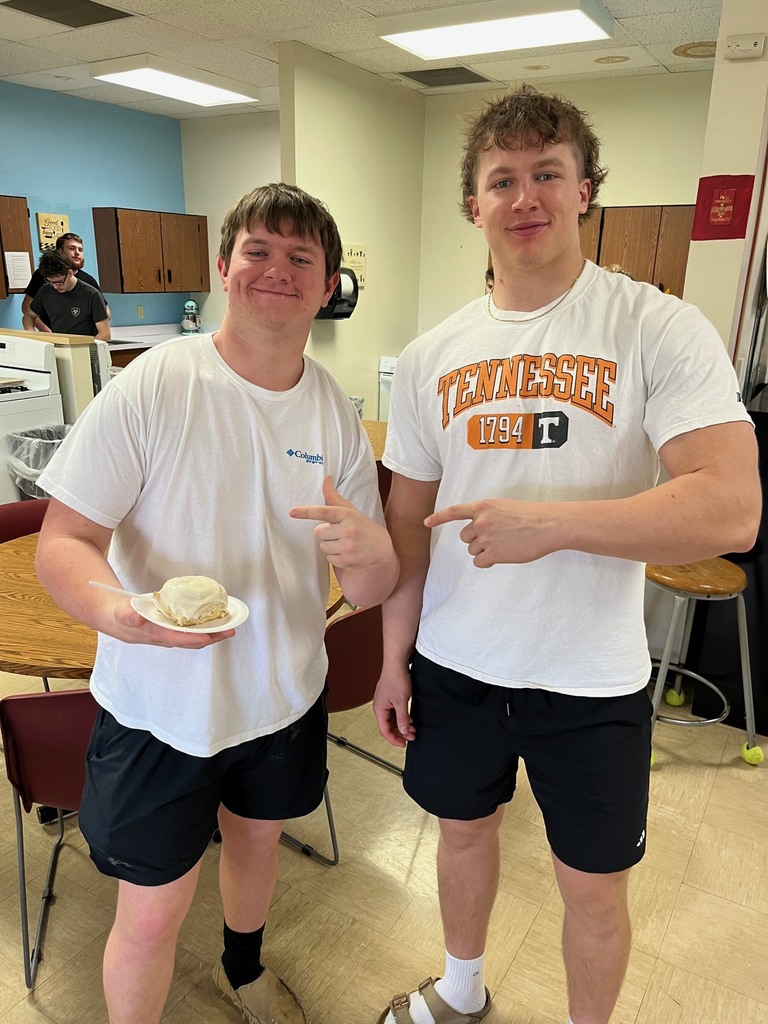 Two students are pointing at their cinnamon roll.