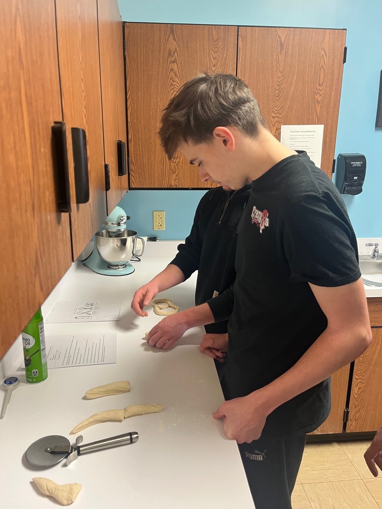 Two students are shaping pretzels.