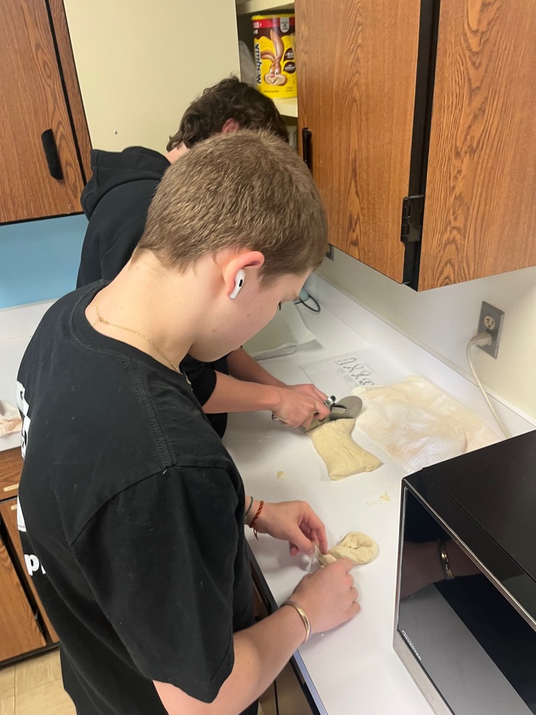 Two students are shaping pretzels.