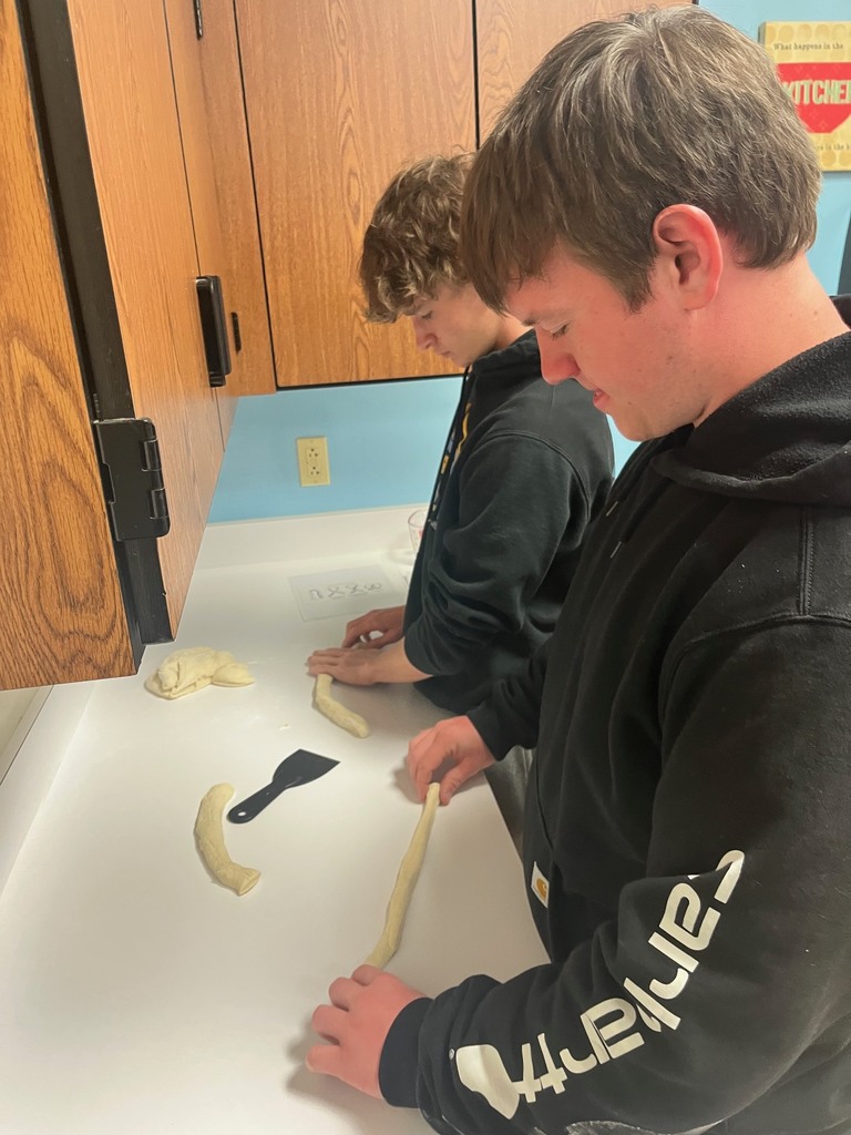 Two students are shaping pretzels.
