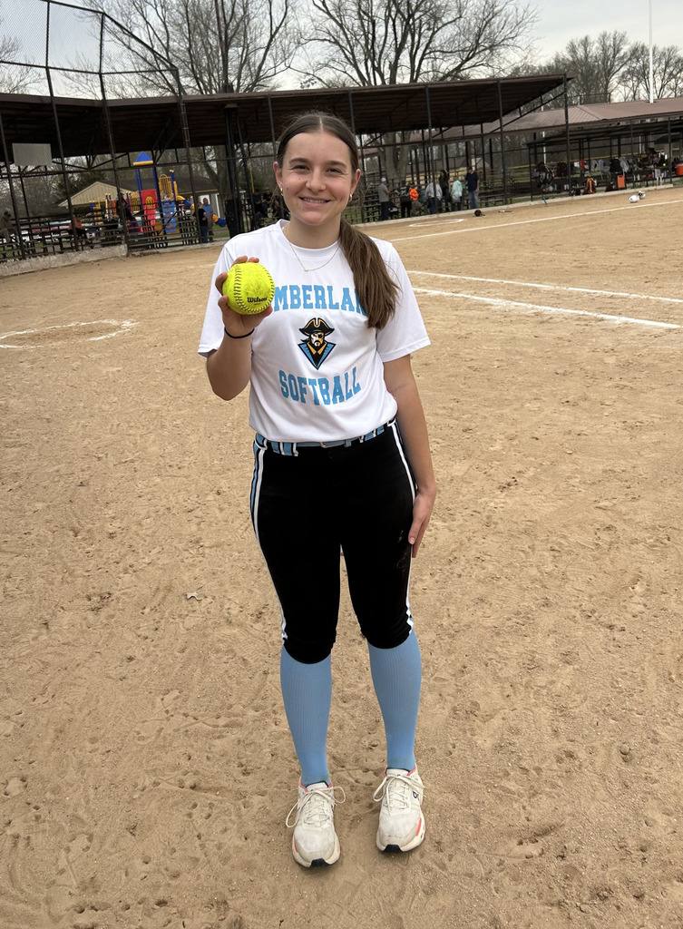 AL is standing on the field holding the home run softball. 