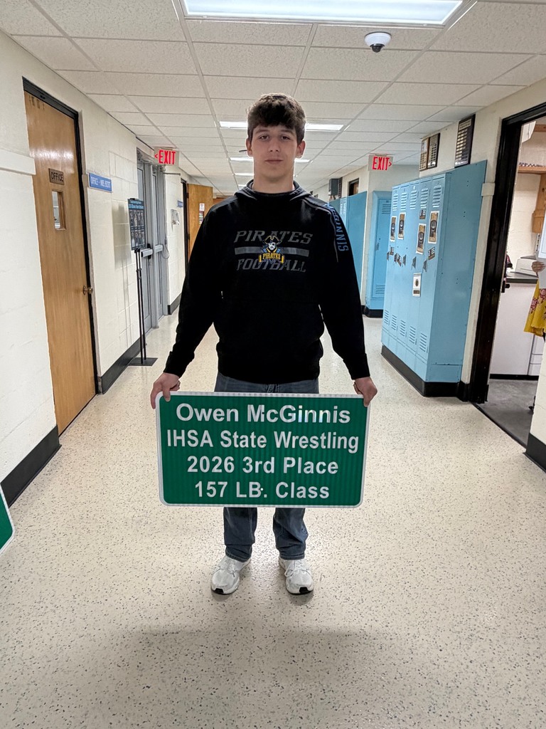A student is holding a sign that reads Owen McGinnis IHSA State Wrestling 2026 3rd Place 157 LB Class.