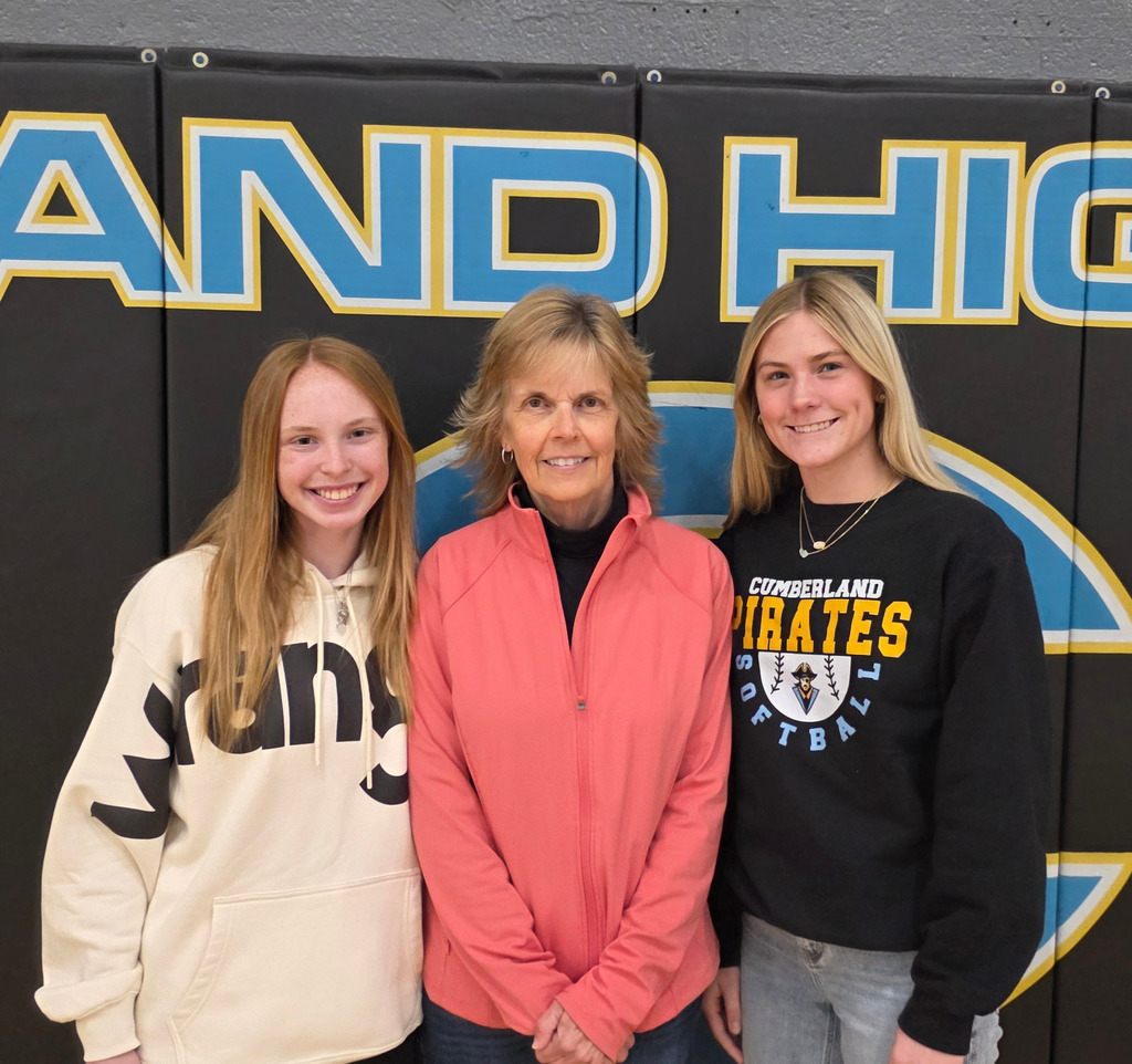 The winner is standing with two softball players.
