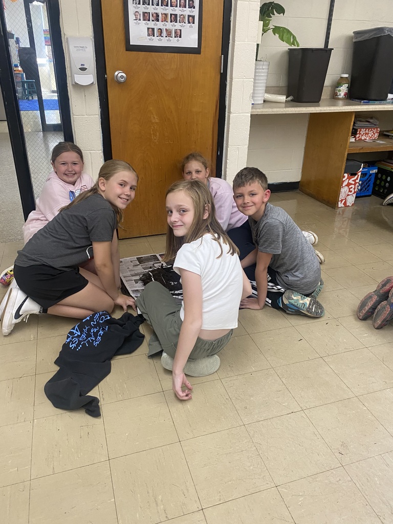 Five students are sifting though the soil to find worm cocoons.  