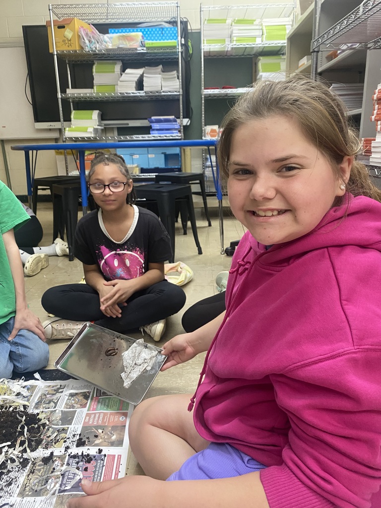 Two students are sifting though the soil to find worm cocoons.  