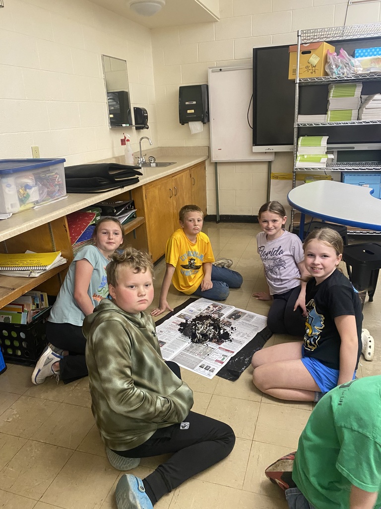 Five students are sifting though the soil to find worm cocoons.  