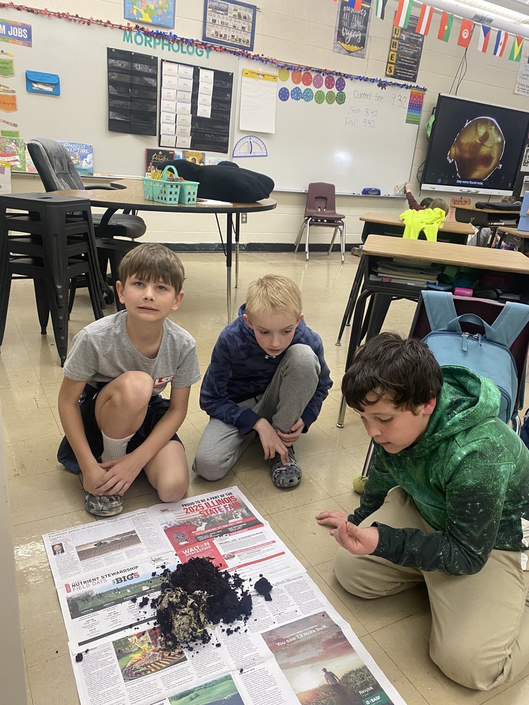 Three students are sifting though the soil to find worm cocoons.  