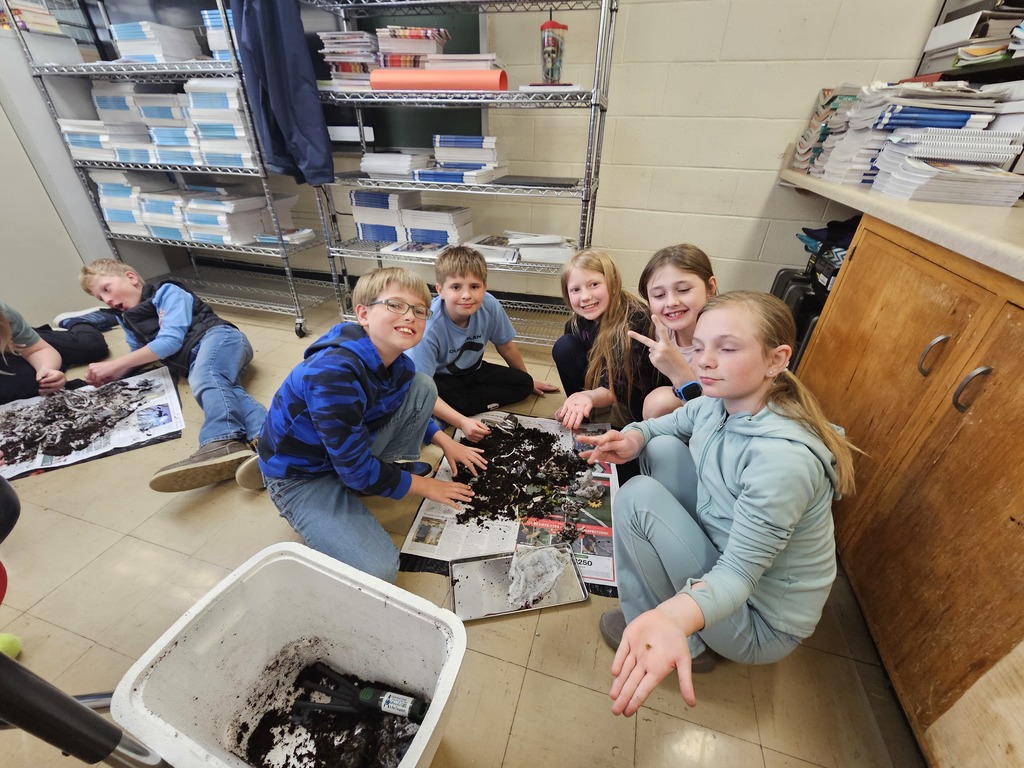 Five students are sifting though the soil to find worm cocoons.  