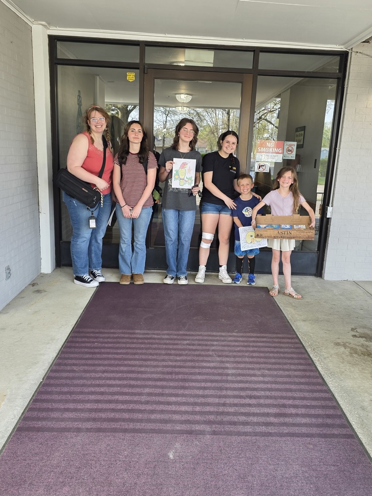 Art club members are standing in front of the nursing home.
