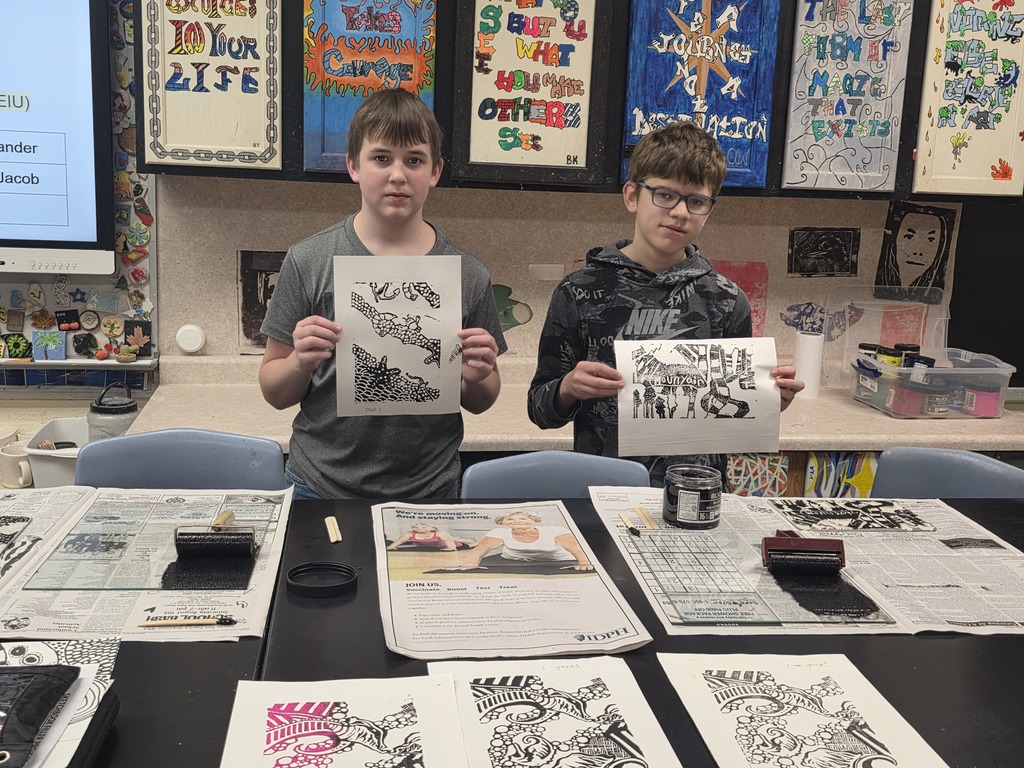 Two students are holding up their print examples.