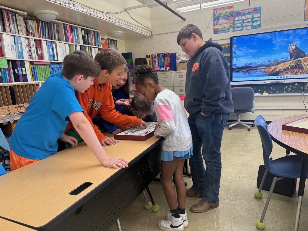 A group of six students are investigating a box of rocks and minerals. 