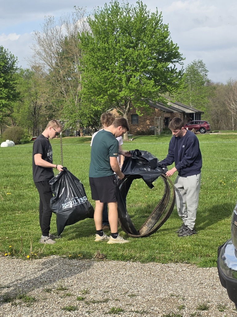 Four students are picking up garbage at the cemetery.
