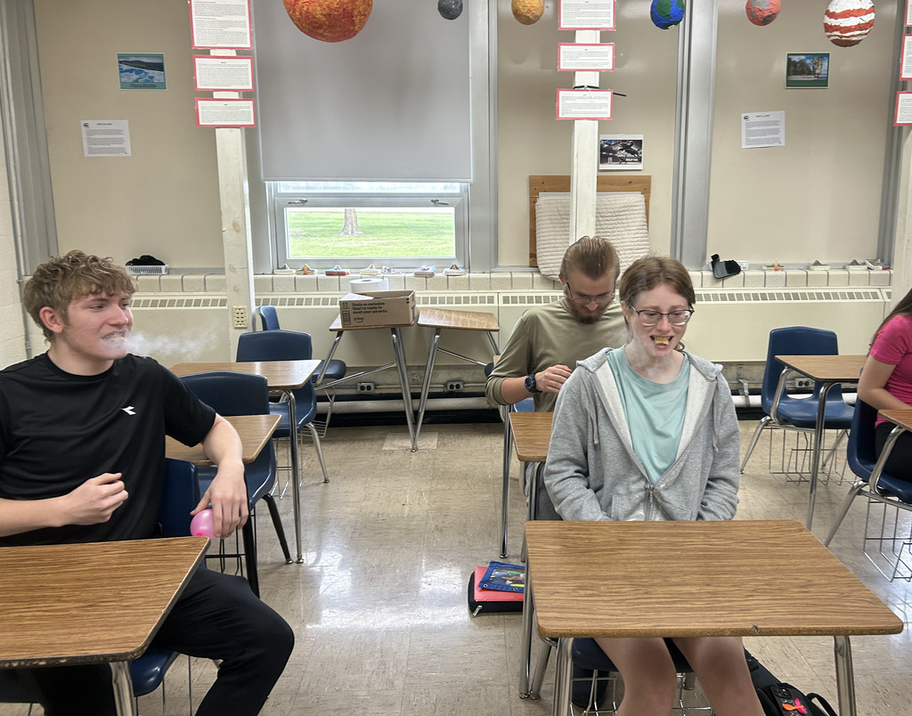 Students have a small piece of something in their mouths that makes it look like they are breathing steam.
