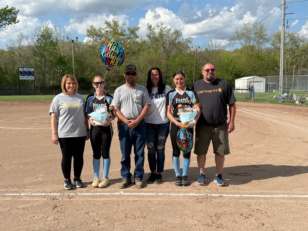 Pictured are the two seniors with their gift baskets and balloons. They are standing with their parents. 