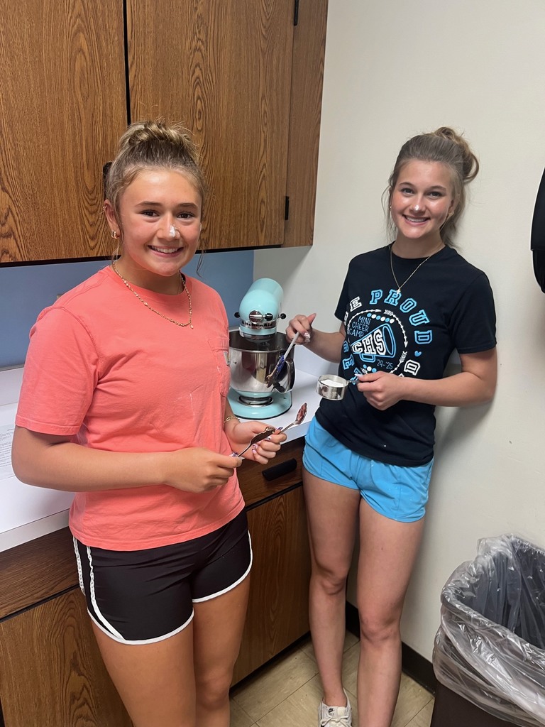 Two students are standing by their mixer. 