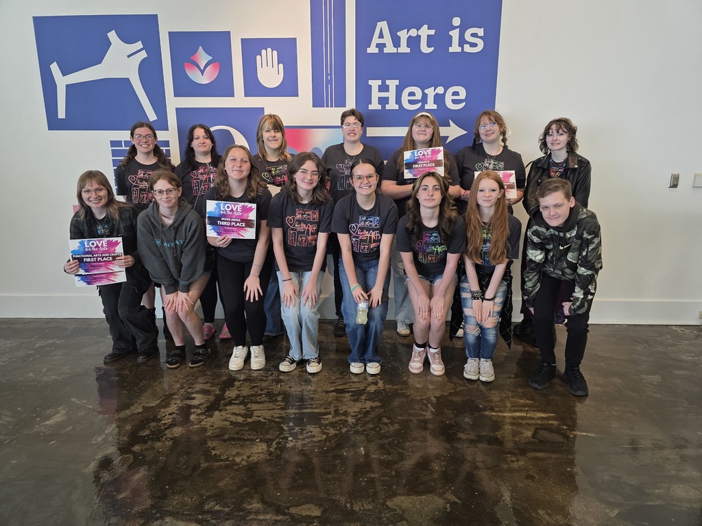The group of 15 art studetns who participated are posing in two rows. Those who won certificates are displaying them. 