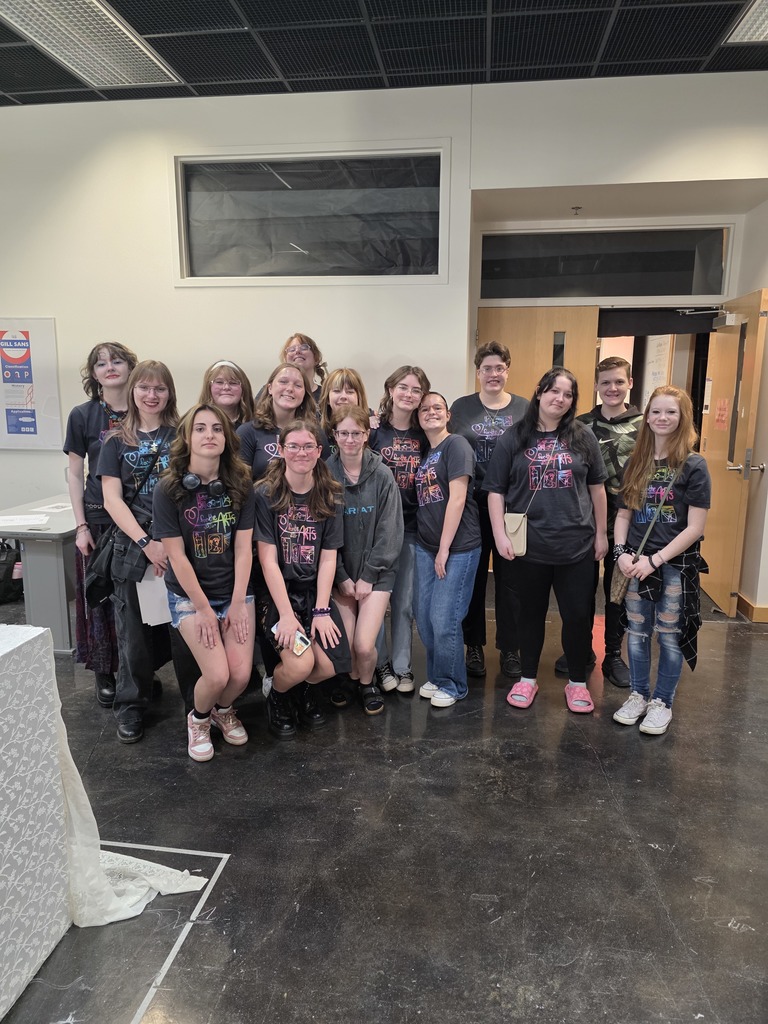The 15 students are posing together in the museum. 