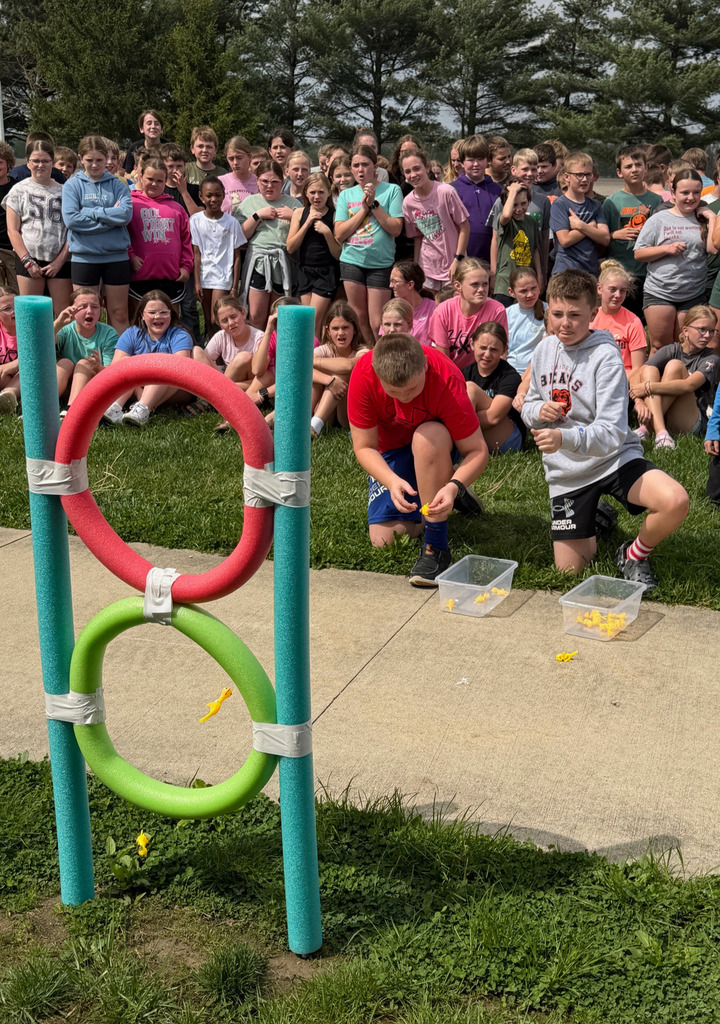 Two students are sending chickens through the rings. They are "chuckin'" them like rubber bands. 