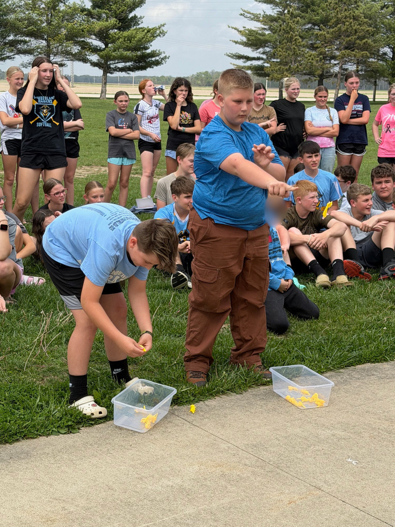 Two students are sending chickens through the rings. They are "chuckin'" them like rubber bands. 