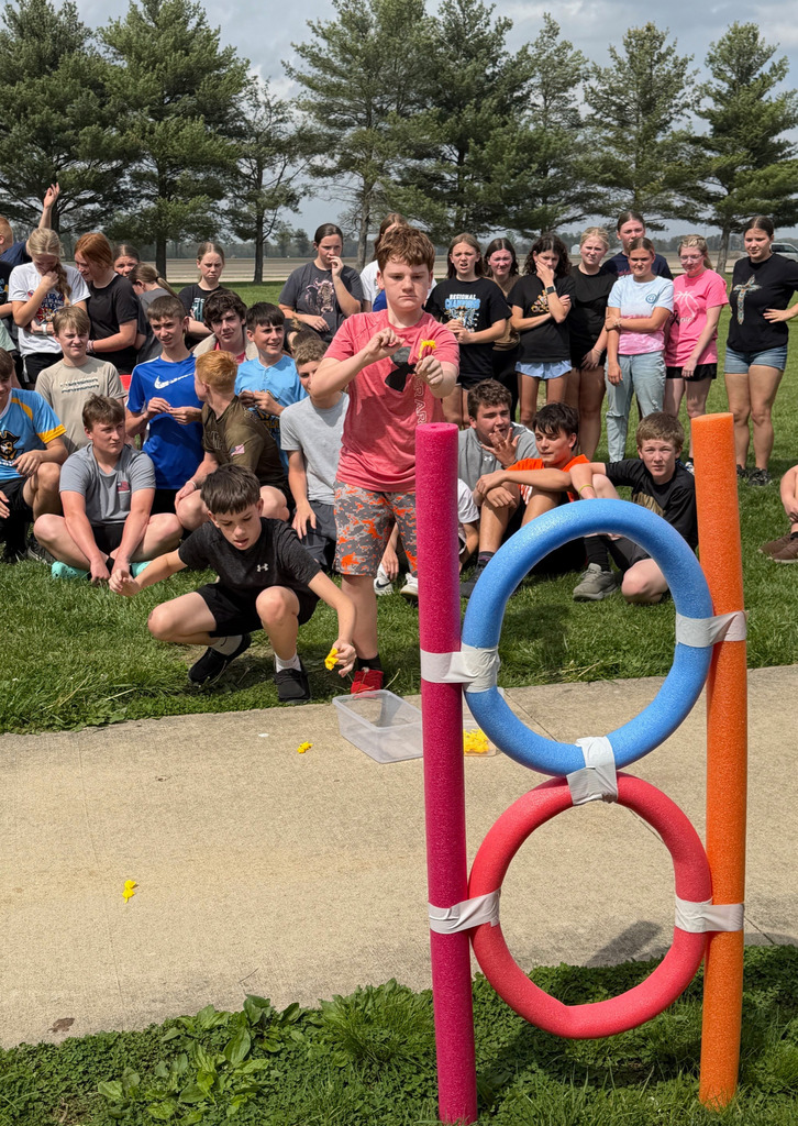 Two students are sending chickens through the rings. They are "chuckin'" them like rubber bands. 