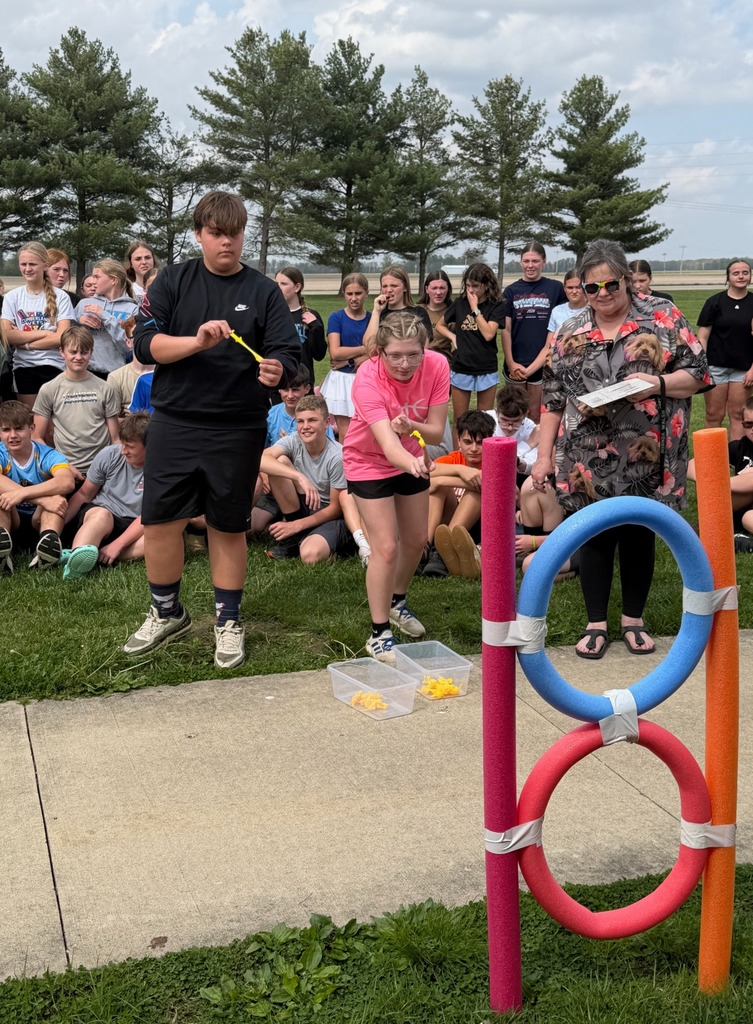 Two students are sending chickens through the rings. They are "chuckin'" them like rubber bands. 