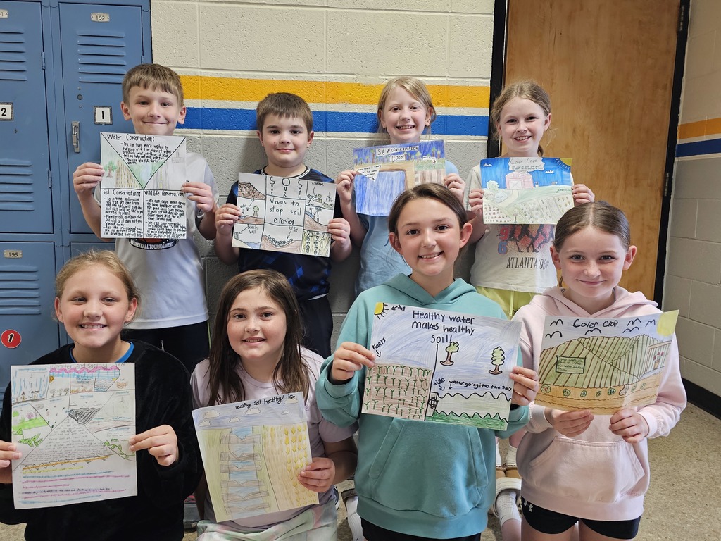 Eight students are holidng their winning posters for soil and water conservation. 
