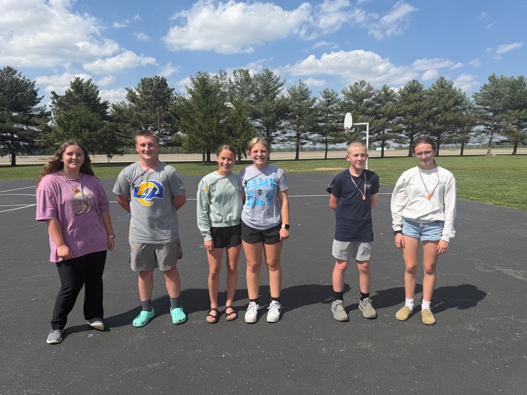 Six  students forming three teams are standing with their medals. 