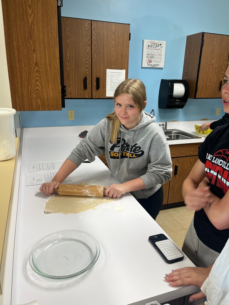 Ond student is rolling the dough.